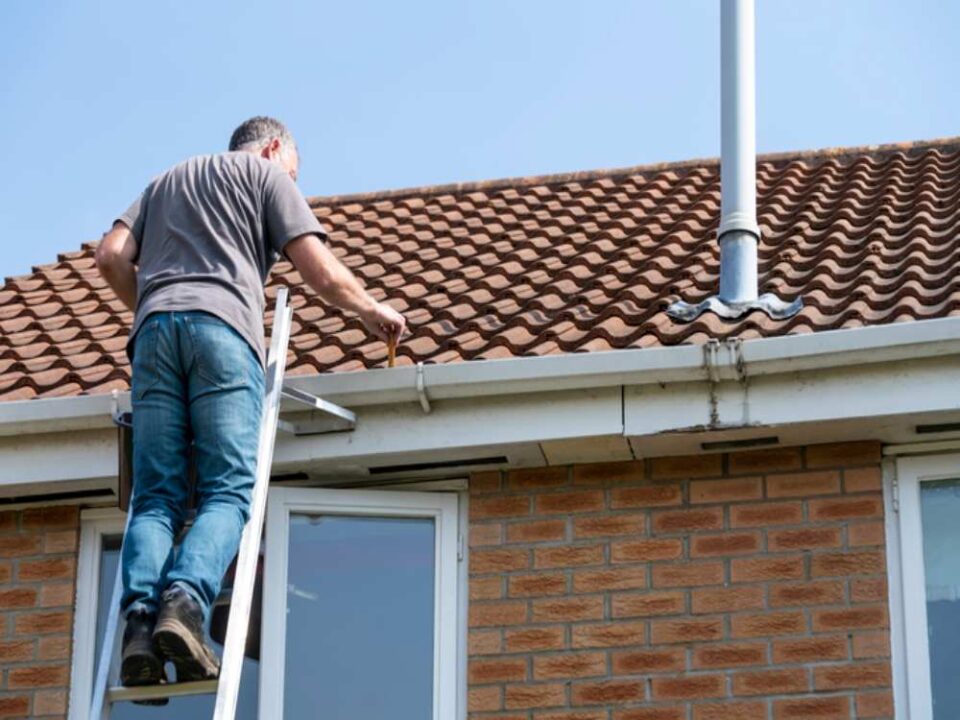 Professional Senior man cleaning gutters in the Greater Annapolis Area